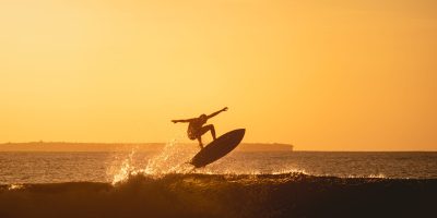 The mesmerizing view of the silhouette of a surfer in the ocean during sunset in Indonesia